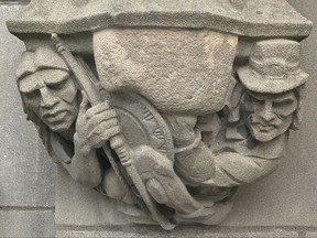 In this July 20, 2017 photo provided by Yale University, a 1929 doorway carving on the school's New Haven, Conn., campus depicts a Puritan settler, right, with a musket pointing at the head of a Native American, left, which had been covered by workers with removable stone when the seldom-used doorway was converted into a main entrance. A Yale committee charged with assessing potentially offensive art decided to remove it, but will make it available for public display elsewhere so as to not destroy "reminders of unpleasant history." (Yale University via AP)
