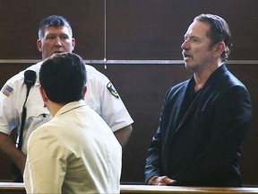 In this still image taken from video, actor Tom Wopat, right, stands during arraignment Thursday, Aug. 3, 2017, in Waltham, Mass., on indecent assault and battery and drug possession charges. Wopat who played Luke Duke on the 1980s television show "The Dukes of Hazzard" pleaded not guilty to the charges. Wopat, 65, was arrested on Wednesday night as he was leaving rehearsal for a performance of "42nd Street." (WCVB-TV via AP, Pool)