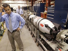 FILE - In this Tuesday, July 31, 2012 file photo, Christopher Del Mastro, head of anti submarine warfare mobil targets stands next to an unmanned underwater vehicle (UUV) in a lab at the Naval Undersea War Center in Middletown, RI. President Donald Trump and U.S. Navy leaders have said that the nation needs about 350 ships, roughly 75 more ships than the fleet has today. Adm. John Richardson, chief of naval operations, said they could get closer to the Navy's goal by counting unmanned vehicles that have capabilities similar to a manned ship. (AP Photo/Stephan Savoia, File)