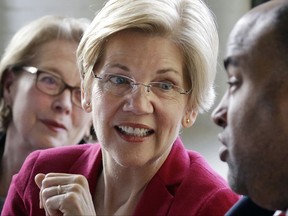 FILE - In this March 3, 2017, file photo, Sen. Elizabeth Warren, D-Mass., center, smiles during a small business roundtable discussion in Lawrence, Mass. At left is Rep. Niki Tsongas, D-Mass., and at right is Lawrence Mayor Daniel Rivera. The Senator won't face re-election until November2018, but two Republicans have announced their candidacies, two others are said to be weighing runs and conservative political groups are chipping away at the candidate. Still, Warren enjoys enormous advantages, including a national base of support, a fat campaign account and solid poll numbers. (AP Photo/Elise Amendola, File)