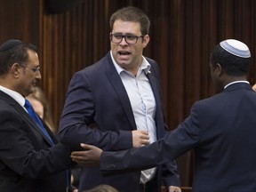 This Wednesday June 17, 2015 file photo shows Oren Hazan, a Likud party parliament member, being escorted out of the parliament hall by ushers