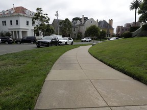 A sidewalk leads into luxury homes in the Presidio Terrace neighborhood, Monday, Aug. 7, 2017, in San Francisco. Thanks to a city auction stemming from an unpaid tax bill, a Bay Area real state investor bought the street in the neighborhood and now owns the sidewalks, the street itself and other areas of "common ground" in the private development that, the San Francisco Chronicle reports, has been managed by the homeowners association since at least 1905. (AP Photo/Marcio Jose Sanchez)