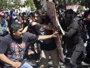 Demonstrators clash during a free speech rally Sunday, Aug. 27, 2017, in Berkeley, Calif. Several thousand people converged in Berkeley Sunday for a "Rally Against Hate" in response to a planned right-wing protest that raised concerns of violence and triggered a massive police presence. Several people were arrested for violating rules against covering their faces or carrying items banned by authorities. (AP Photo/Josh Edelson)