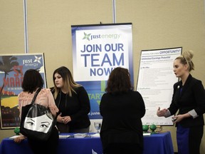 In this Thursday, Aug. 24, 2017, photo, Heather Snow, at right, and Daisy Medina, second from left, recruiters for Just Energy, talk to job seekers during a job fair in San Jose, Calif. Changing careers takes energy, money and time. Before giving up the security of your current position, there are steps you can take to be sure you're making the right decision. (AP Photo/Marcio Jose Sanchez)