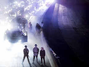 Police officers stand watch as protesters against racism block traffic on both directions of Interstate 580 in Oakland, Calif., Saturday, Aug. 12, 2017. Several hundred demonstrators marched to decry racism in the wake of deadly violence that erupted at a white nationalist rally in Virginia. (AP Photo/Noah Berger)