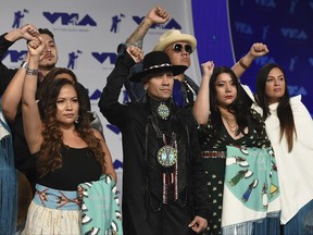Taboo, center, and Native American musicians raise their fists in protest of the Dakota Access Pipeline as they arrive at the MTV Video Music Awards at The Forum on Sunday, Aug. 27, 2017, in Inglewood, Calif. (Photo by Jordan Strauss/Invision/AP)