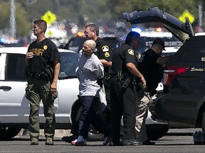 A suspect believed to be involved in the shooting of law enforcement officers is taken from the scene by Sacramento County Sheriff's Deputies, Wednesday, Aug. 30, 2017, in Sacramento, Calif. (AP Photo/Rich Pedroncelli)