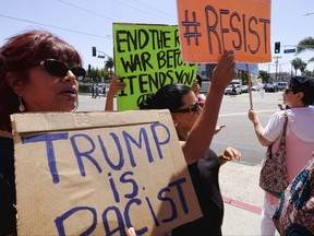 Demonstrators carrying signs in protest to racism walk along Main Street in the Venice beach area of Los Angeles on Saturday, Aug. 19, 2017. Hundreds of people rallied in Southern California to condemn racism in the wake of the deadly events in Charlottesville, Va. (AP Photo/Richard Vogel)