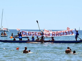 People hold banners and flags as they take part in demonstration titled, City Flotilla, at Sea Against Racism, to protest against the scheduled arrival of the C Star, a ship that an anti-immigrant group has chartered to try and halt migrant arrivals to Europe from Africa and elsewhere, in Catania, Sicily Island, Italy, Saturday,  July 29, 2017. (Orietta Scardino/ANSA via AP)