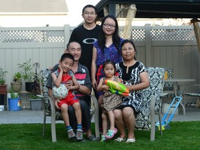 Yi Jiang and husband Jianqiao Sun, back, stand as grandparents Youfang Jiang and Li Zhang sit with grandson Sunny Jiang and granddaughter Jenny Sun in the backyard of their home in Ottawa. The family immigrated to Canada from China and live together as a multi-family household.