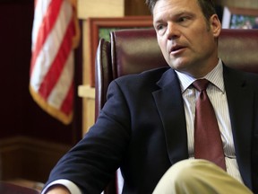 FILE - In this May 17, 2017, file photo, Kansas Secretary of State Kris Kobach talks with a reporter in his office in Topeka. Kobach, co-chairman of President Donald Trump's Presidential Advisory Commission on Election Integrity who is promoting Trump's unsubstantiated claims of widespread voter fraud, oversees a Kansas election system that threw out at least three times as many ballots as similarly sized states did. That is fueling concerns about massive voter suppression should its practices become the national standard. (AP Photo/Orlin Wagner, File)