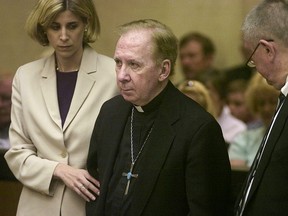 In this March 26, 2004, file pool photo, Bishop Thomas O'Brien, center, is flanked by attorneys, Melissa Berren, left, and Tom Henze, right, as they stand before Judge Stephen Gerst in a courtroom in Phoenix.