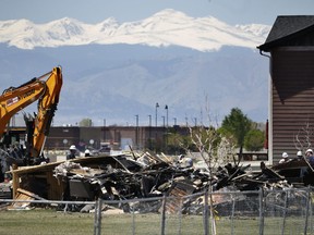 FILE - In this May 4, 2017, file photo, workers dismantle the charred remains of a house destroyed by an explosion triggered by natural gas in Firestone, Colo. The April 17, blast killed two people. Investigators blamed the explosion on gas leaking from a severed pipeline that was thought to have been abandoned but was still connected to a well. Colorado Gov. John Hickenlooper said Tuesday, Aug. 22, that the state is tightening regulations on oil and gas pipelines to reduce the chances of another such explosion. (AP Photo/Brennan Linsley, File)