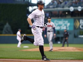 Colorado Rockies' DJ LeMahieu scores from third base on an infield out by Gerardo Parra as Atlanta Braves starting pitcher Mike Foltynewicz stands at the base of the mound during the first inning of a baseball game Wednesday, Aug. 16, 2017, in Denver. (AP Photo/David Zalubowski)