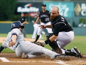 Colorado Rockies catcher Jonathan Lucroy, right, tags out Milwaukee Brewers' Neil Walker as he tries to steal home plate from third base during a double steal in the first inning of a baseball game Saturday, Aug. 19, 2017, in Denver. (AP Photo/David Zalubowski)