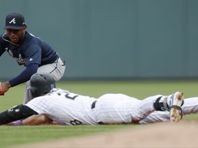 Colorado Rockies' Nolan Arenado, front, slides safely into second base with a double as Atlanta Braves second baseman Ozzie Albies turns to apply the tag in the first inning of a baseball game Thursday, Aug. 17, 2017, in Denver. (AP Photo/David Zalubowski)