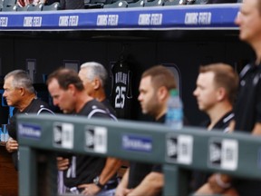 The jersey of former Colorado Rockies manager Don Baylor hangs in the dugout as members of the Colorado Rockies bow their heads in a moment of silence before a baseball game against the Atlanta Braves Monday, Aug. 14, 2017, in Denver. Baylor died Aug. 7, 2017. (AP Photo/Jack Dempsey)