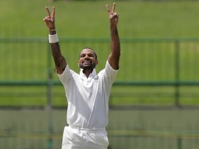 India's Shikhar Dhawan gestures towards team's dressing room as he celebrates scoring a century during the first day's play of their third cricket test match against Sri Lanka in Pallekele, Sri Lanka, Saturday, Aug. 12, 2017. (AP Photo/Eranga Jayawardena)