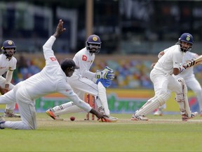 India's Cheteshwar Pujara, right, plays a shot during their second cricket test match against Sri Lanka in Colombo, Sri Lanka, Thursday, Aug. 3, 2017. (AP Photo/Eranga Jayawardena)