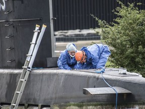 Police technicians board the amateur-built submarine UC3 Nautilus on a pier in Copenhagen harbour, Denmark, Monday  Aug. 14, 2017, to conduct forensic probes in connection with a missing journalist investigation.  Police from Sweden were assisting their Danish counterparts on Tuesday for clues in the search for a missing Swedish woman who apparently was aboard an amateur-built submarine a day before it sank. (Mogens Flindt/Ritzau Foto via AP)