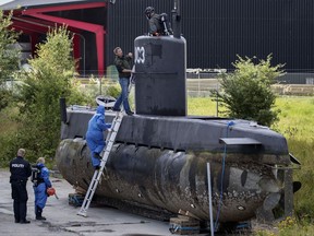 Police technicians board the amateur -built submarine UC3 Nautilus on a pier in Copenhagen harbour, Denmark, Sunday, Aug. 13, 2017, to conduct forensic probes in connection with a murder investigation. Danish police say they have not found the body of a missing Swedish journalist inside the submarine that sunk off the Nordic country's eastern coast last week. (Jacob Ehrbahn/Ritzau Foto via AP)