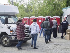 The Liberal government is misleading people when it says there's no advantage to crossing illegally into Canada to seek asylum, NDP MP Jenny Kwan says. Asylum seekers line up to receive boxed lunches after entering Canada from the United States at Roxham Road in Hemmingford, Que., Wednesday, August 9, 2017. THE CANADIAN PRESS/Graham Hughes