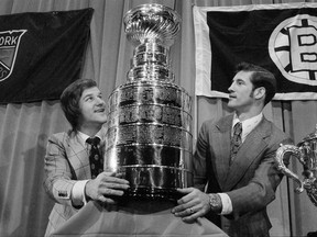 Boston Bruins' Bobby Orr , left, and New York Rangers' Jean Ratelle hold the Stanley Cup at a luncheon in New York, May 5, 1972. The New York Rangers will retire Ratelle's No. 19 and the Philadelphia Flyers will retire Eric Lindros' No. 88 this season. THE CANADIAN PRESS/AP/Harry Harris
