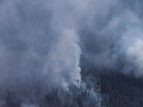 A wildfire is seen from a Canadian Forces Chinook helicopter as Prime Minister Justin Trudeau views areas affected by wildfire near Williams Lake, B.C., on Monday July 31, 2017. British Columbia is poised to face its worst wildfire season as flames scorch thousands of hectares of land and costs rise to deal with the devastation. THE CANADIAN PRESS/Darryl Dyck