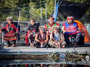 Protesters gather at the Marine Harvest fish farm on Swanson Island, near Alert Bay, B.C. in a handout photo from the Facebook page Swanson Occupation. Ernest Alfred, 36, sitting cross-legged on the right wearing a cedar bark neck ring, sits with other traditional leaders from neighbouring villages. THE CANADIAN PRESS/HO-Facebook-Swanson Occupation MANDATORY CREDIT