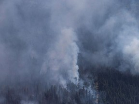 A wildfire is seen from a Canadian Forces Chinook helicopter as Prime Minister Justin Trudeau views areas affected by wildfire near Williams Lake, B.C., on Monday July 31, 2017. An evacuation order affecting about 1,100 people living east of Kelowna, B.C., was issued Thursday because of the threat of a wildfire. Elsewhere, calmer weather and continuing progress battling some of the other wildfires in the province means more people can return home while campers and hikers will be able to access more of the backcountry in the Interior. THE CANADIAN PRESS/Darryl Dyck