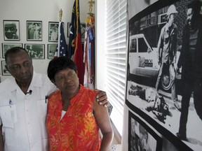 Aug. 16, 2017, the Rev. Nelson Johnson and his wife, Joyce, stand beside a 1979 photo of the "Greensboro Massacre" at the couple's Faith Community Church in Greensboro, N.C. The Johnsons were taking part in a workers' march on Nov. 3, 1979, when they were attacked by Nazis and members of the Ku Klux Klan.