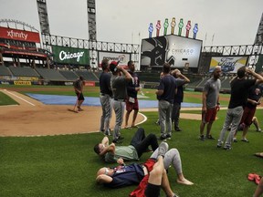 Members of Minnesota Twins watch the solar eclipse before a baseball game between the Minnesota Twins and Chicago White Sox at Guaranteed Rate Field, Monday, Aug. 21, 2017, in Chicago. (AP Photo/Paul Beaty)