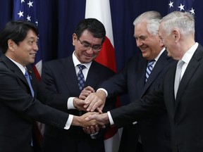 Japanese Defense Minister Itsunori Onodera, left, Japanese Foreign Minister Taro Kono, Secretary of State Rex Tillerson, and Defense Secretary James Mattis, gather for an "ASEAN" style handshake at the start of a Security Consultative Committee meeting, Thursday, Aug. 17, 2017, at the State Department in Washington. (AP Photo/Jacquelyn Martin)