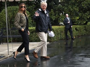 President Donald Trump, accompanied by first lady Melania Trump, waves as they walk from the White House to the South Lawn, Tuesday, Aug. 29, 2017, to board Marine One for a short trip to Andrews Air Force Base, Md.m then onto Texas to view the federal government's response to Harvey's devastating flooding in Texas. (AP Photo/Jacquelyn Martin)