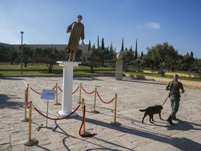 A security guard patrols near a golden statue of the Israel's Supreme Court's president Miram Noar outside the court Thursday, Aug. 31, 2017. Members of a right-wing religious group in Israel erected the statue in protest of the court's "dictatorship." Police removed the statue put up outside the court overnight and questioned individuals suspected of involvement, but said no criminal activity was suspected. (AP Photo/Olivier Fitoussi)