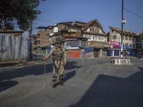 Indian paramilitary soldiers stand guard at a temporary check point during curfew in Srinagar, Indian controlled Kashmir, Saturday, Aug. 12, 2017. Government forces imposed curfew-like restrictions in many parts of Indian controlled Kashmir after separatists leaders called for strike against dilution of article 35A. The article empowers the Jammu and Kashmir state legislature to define permanent residents of the state and provide special rights and privileges to those permanent residents. (AP Photo/Dar Yasin)