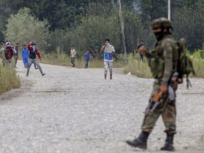Kashmiri protesters clash with Indian army soldiers near the site of a gunbattle in Pulwama, about 35 Kilometers south of Srinagar, Indian controlled Kashmir, Saturday, Aug. 26, 2017. At least two gunmen entered a police camp in southern Pulwama town firing guns and grenades at the sentry, said Director-General of police S.P. Vaid. (AP Photo/Dar Yasin)