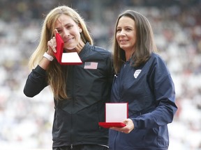 Kara Goucher, left, wipes away a tear as she stands with Jo Pavey during a ceremony at the world athletics championships in London on Saturday, Aug. 5, 2017. Goucher and Pavey received medals for the women's 10,000 metres at the 2007 world championships following the doping disqualification in 2015 of the original silver medallist.
