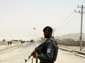 An Afghan policeman stands guard near to the site of a suicide bomber struck at a NATO convoy in Kandahar southern of Kabul, Afghanistan, Wednesday, Aug. 2, 2017. A suicide bomber struck a NATO convoy near the southern Afghan city of Kandahar on Wednesday, causing casualties.