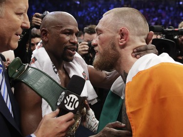 Floyd Mayweather Jr., embraces Conor McGregor in the ring after their super welterweight boxing match.