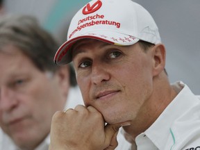 FILE - In this Thursday, Oct. 4, 2012 file photo, former Mercedes F1 driver Michael Schumacher of Germany pauses during a news conference to announce his retirement from Formula One at the end of 2012 in Suzuka, Japan. It was announced Thursday Aug. 24, 2017 that Michael Schumacher's 18 year old son, Mick, will mark the 25th anniversary of his father's first Formula One win by driving demonstration laps ahead of the Belgian Grand Prix on Sunday, Aug. 27. (AP Photo/Shizuo Kambayashi, File)