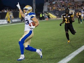 Winnipeg Blue Bombers receiver Julian Feoli-Gudino, left, scores a touchdown against the Hamilton Tiger-Cats on Aug. 12.
