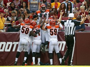 Cincinnati Bengals outside linebacker Vontaze Burfict, top, celebrates with teammates after intercepting a pass by Washington Redskins quarterback Kirk Cousins and scoring a touchdown in the first half of a preseason NFL football game, Sunday, Aug. 27, 2017, in Landover, Md. (AP Photo/Alex Brandon)