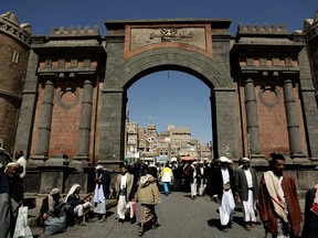 Yemenis walk under the iconic Yemen Gate leading to the old city of Sanaa.