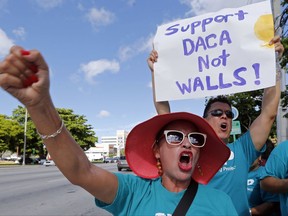 Immigration rights activist Celia Yamasaki, of San Antonio, Texas, urges Republican lawmakers in Florida to firmly oppose President Donald Trump's proposals to increase funding for immigration enforcement as deadlines for budget decisions near in Congress, Tuesday, Aug. 8, 2017, in Doral, Fla. Advocates from Texas, New Mexico and Washington D.C. expressed anger on Tuesday at Rep. Mario Diaz-Balart for backing a spending bill that gives $1.6 million for Trump's controversial border wall. Other bills would add immigration agents and judges. (AP Photo/Alan Diaz)