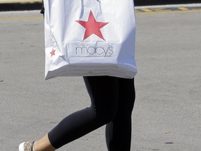In this Thursday, May 11, 2017, photo, a shopper carries a bag as she walks in the parking lot of a shopping mall in Hialeah, Fla. Macy's Inc. reports earnings, Thursday, Aug. 10, 2017. (AP Photo/Alan Diaz)
