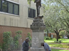 Workers begin removing a Confederate statue in Gainesville, Fla., Monday, Aug. 14, 2017. The statue is being returned to the local chapter of the United Daughters of the Confederacy, which erected the bronze statue in 1904. County officials said they did not know where the statue would be going. (AP Photo/Jason Dearen)