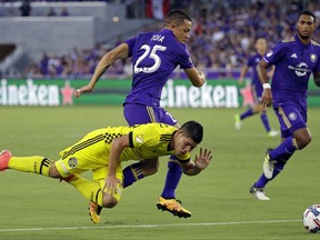 Columbus Crew's Cristian Martinez, front left, falls after becoming entangled with Orlando City's Donny Toia (25) during the first half of an MLS soccer match, Saturday, Aug. 19, 2017, in Orlando, Fla. (AP Photo/John Raoux)