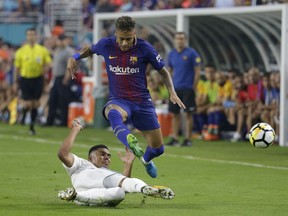 Real Madrid's Casemiro, left, falls to the field as he vies for the ball with Barcelona's Neymar, right, during the first half of an International Champions Cup soccer match, Saturday, July 29, 2017, in Miami Gardens, Fla. (AP Photo/Lynne Sladky)