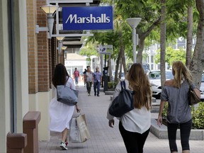 In this Friday, May 19, 2017, photo, shoppers walk past a Marshalls store in Miami. Consumer spending slowed in June as income growth turned in the weakest performance in seven months, according to information released Tuesday, Aug. 1, 2017, by the Commerce Department. (AP Photo/Lynne Sladky)